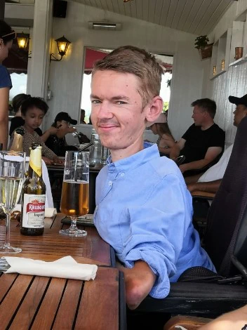 Patrik Wolff, Permobil user, sits by the table with a beer 