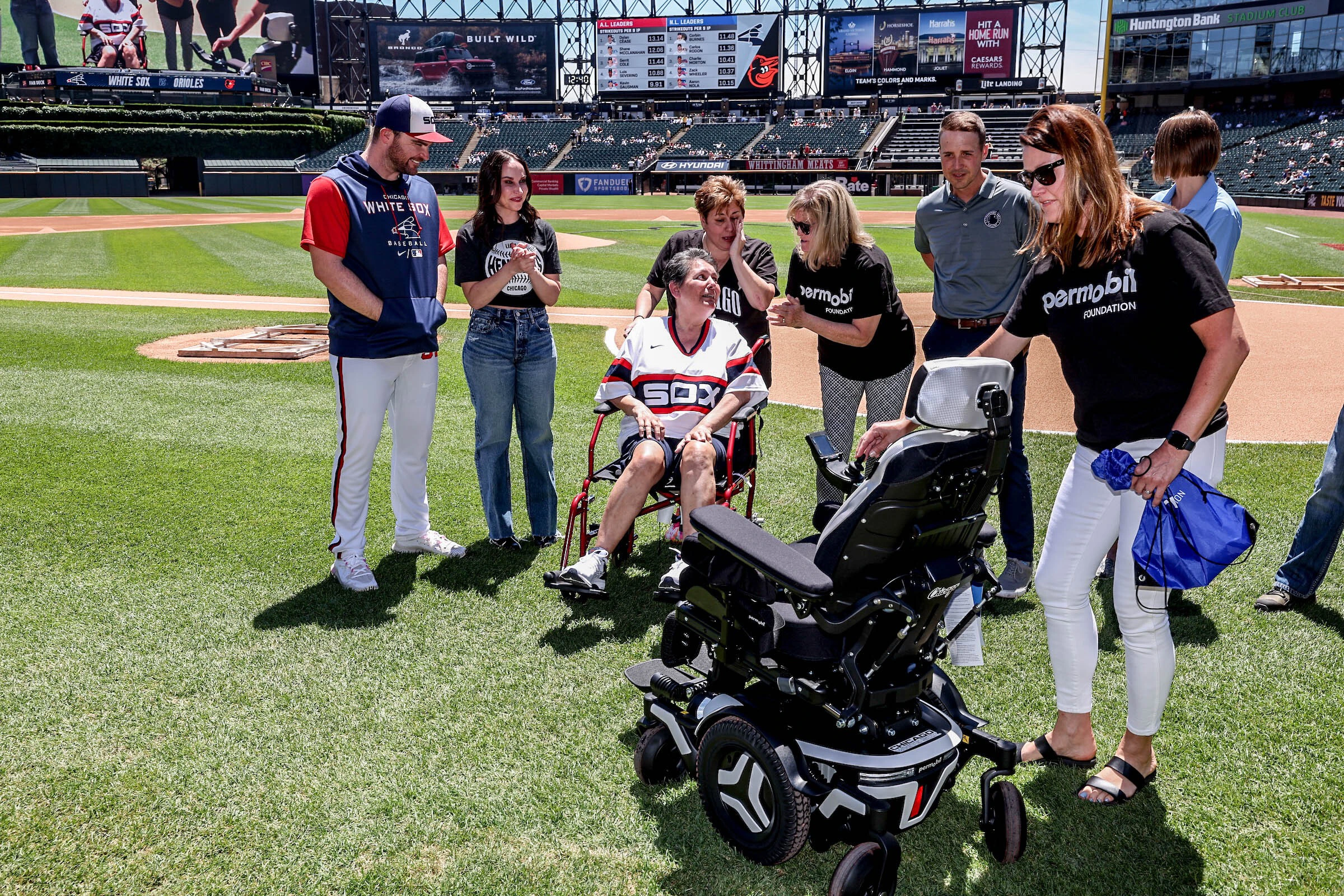 On the field at a White Sox game, giving the donation of a power chair to someone who only has a manual chair