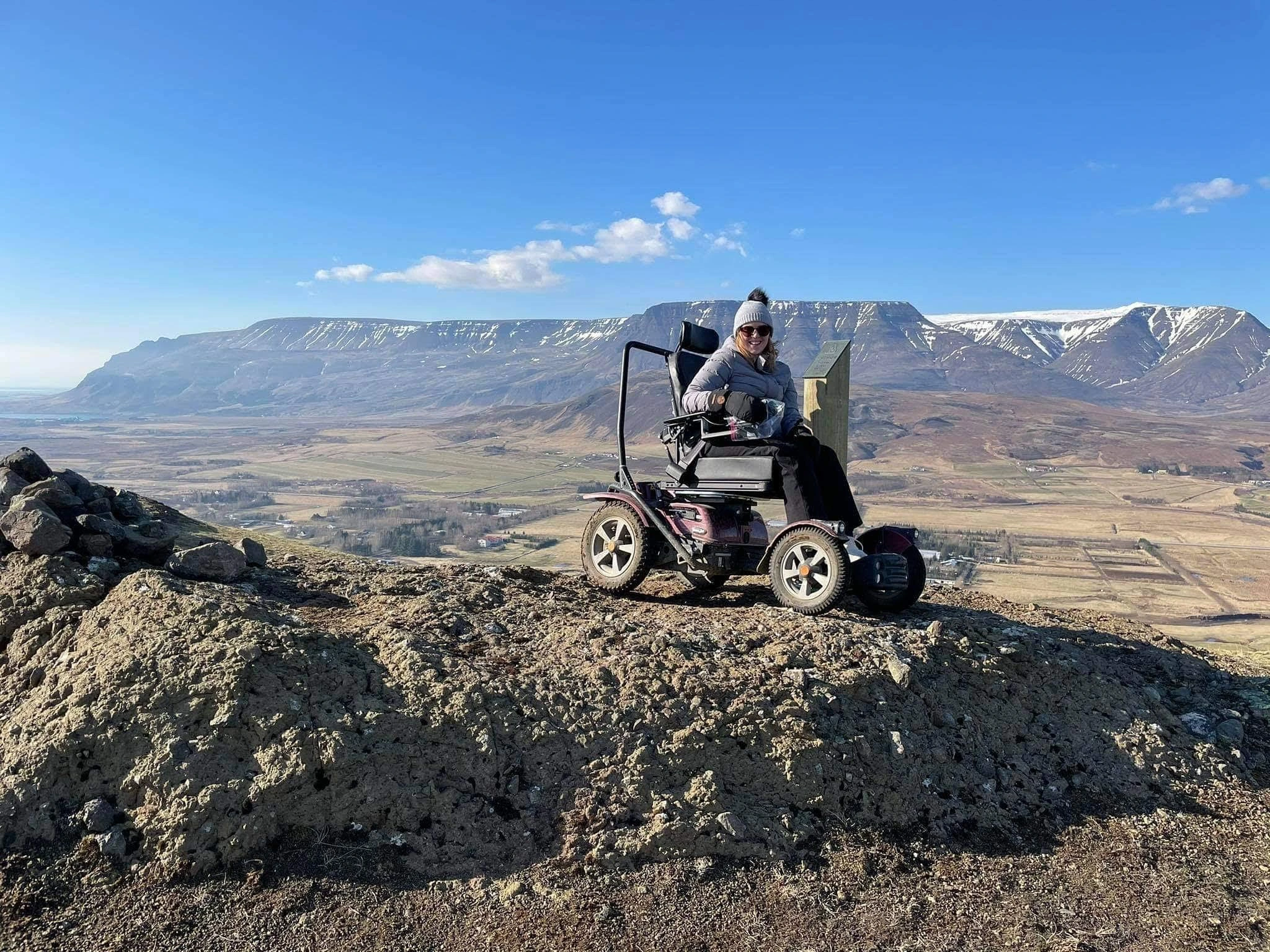 Young woman in an x850 on a rocky mound with Icelandic mountains and blue sky in the background